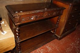 A Victorian oak three tier buffet , heavily carved with two frieze drawers. 114cm wide.