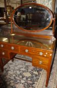 A 1930's mahogany dressing table with oval mirror, 114cm wide, and a matching chest of drawers.