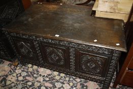 A late 17th century oak coffer with a triple carved panel front and carved stiles, 131cm