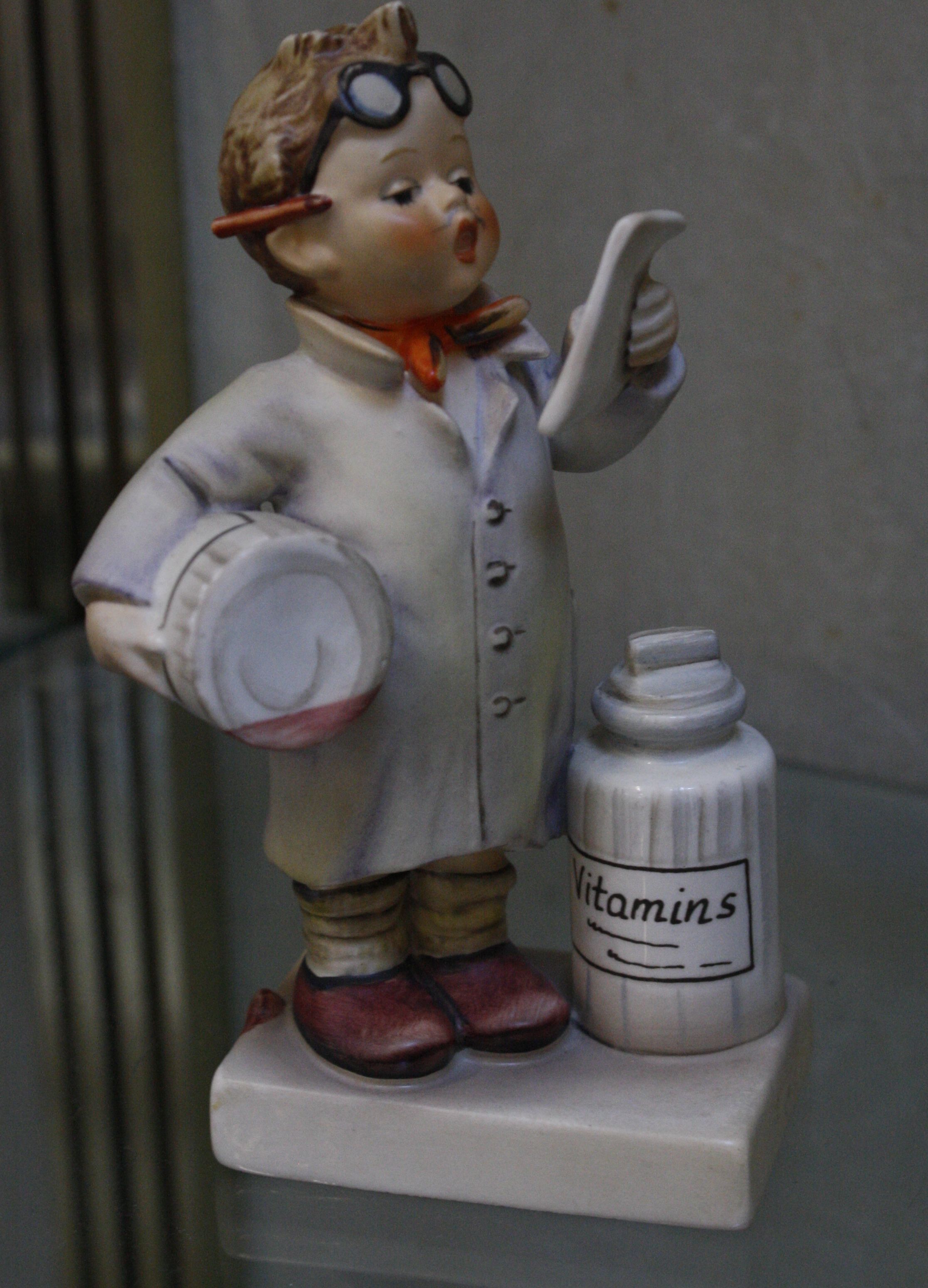 A Hummel figure of a boy with vitamin bottles, 14cm high