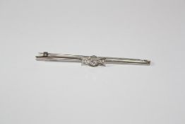 A 18ct white gold, platinum and diamond bar brooch, set with three stones