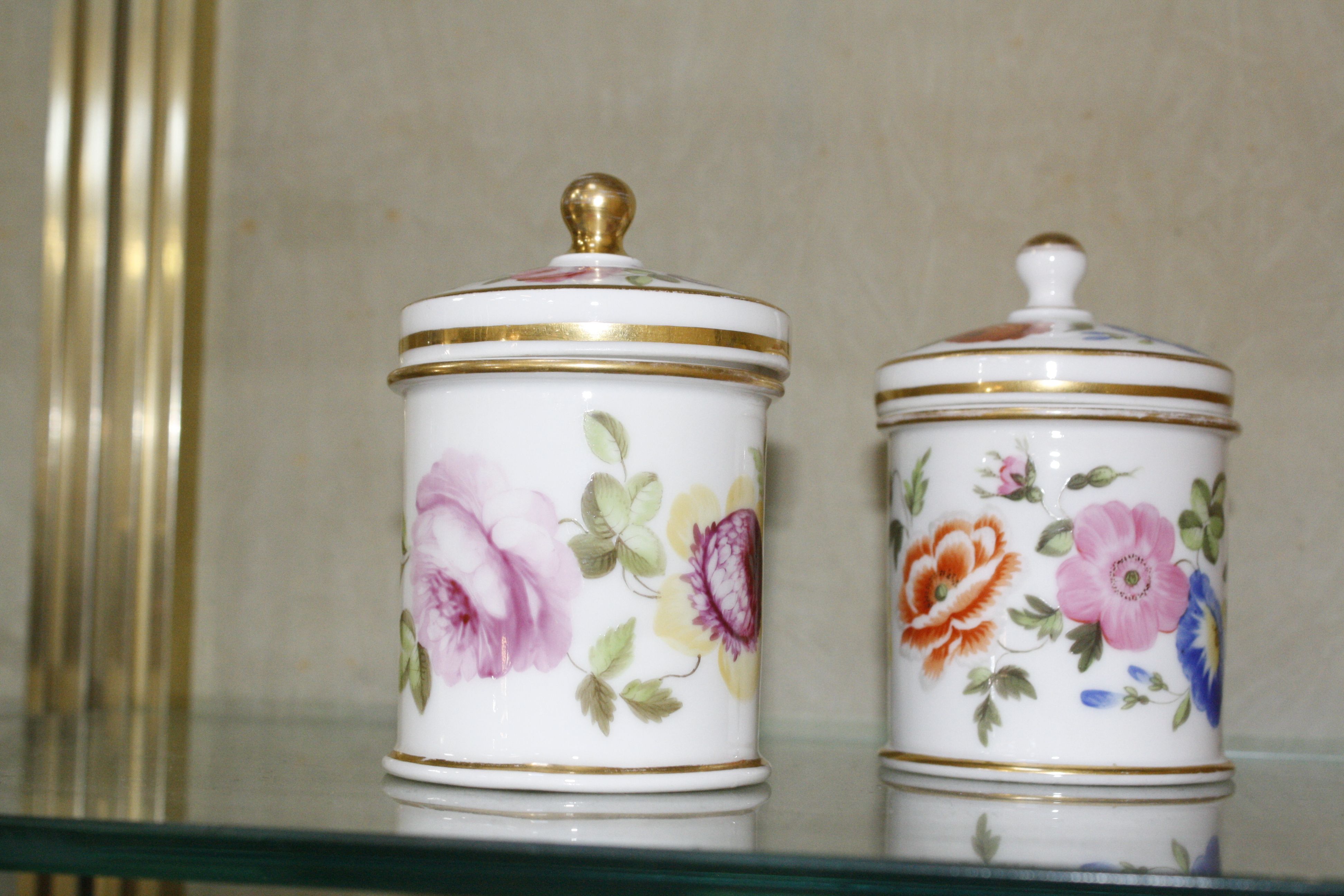 A pair of porcelain pots with covers, floral decorated, 10.5cm high (2)