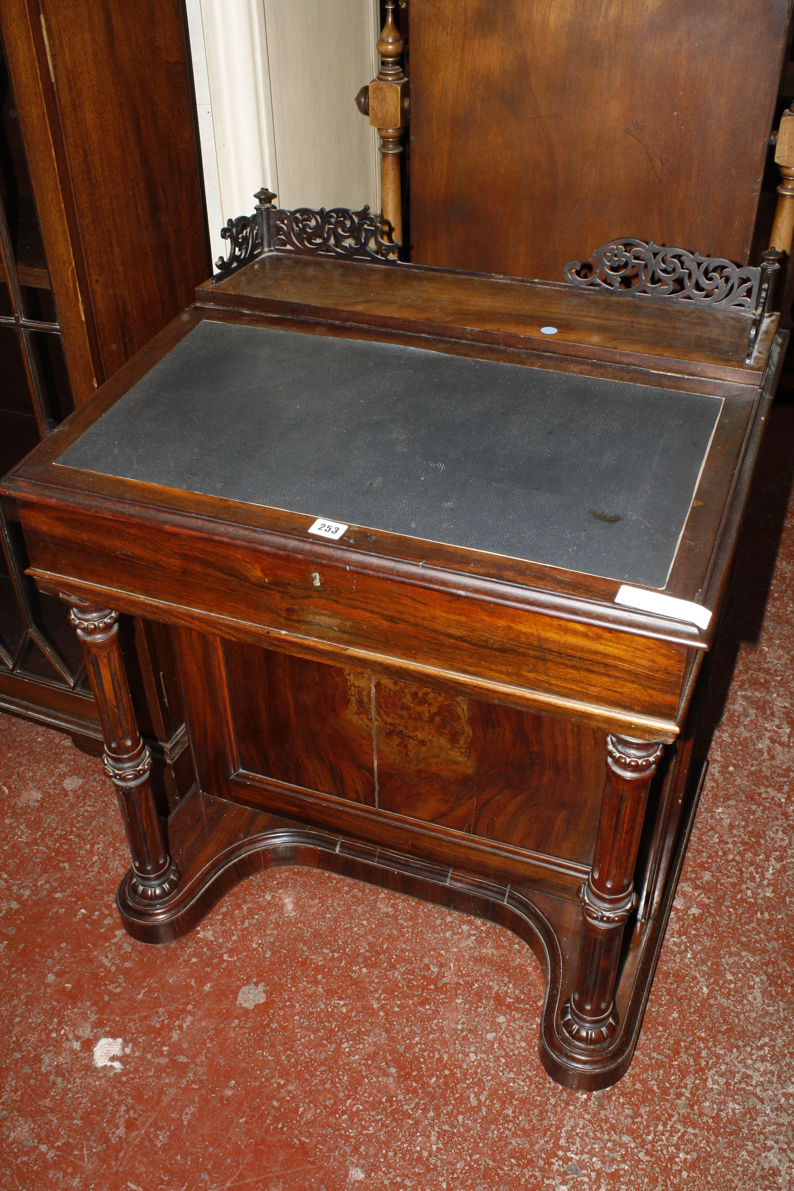 A Victorian rosewood davenport, with a pierced gallery sloping fall supported on fluted columns