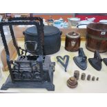A quantity of black cast iron items to include a pot with cover, irons, an oak barrel and oak