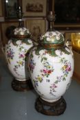 A pair of ceramic vases with covers, converted into table lamps, floral decorated (sold as parts)