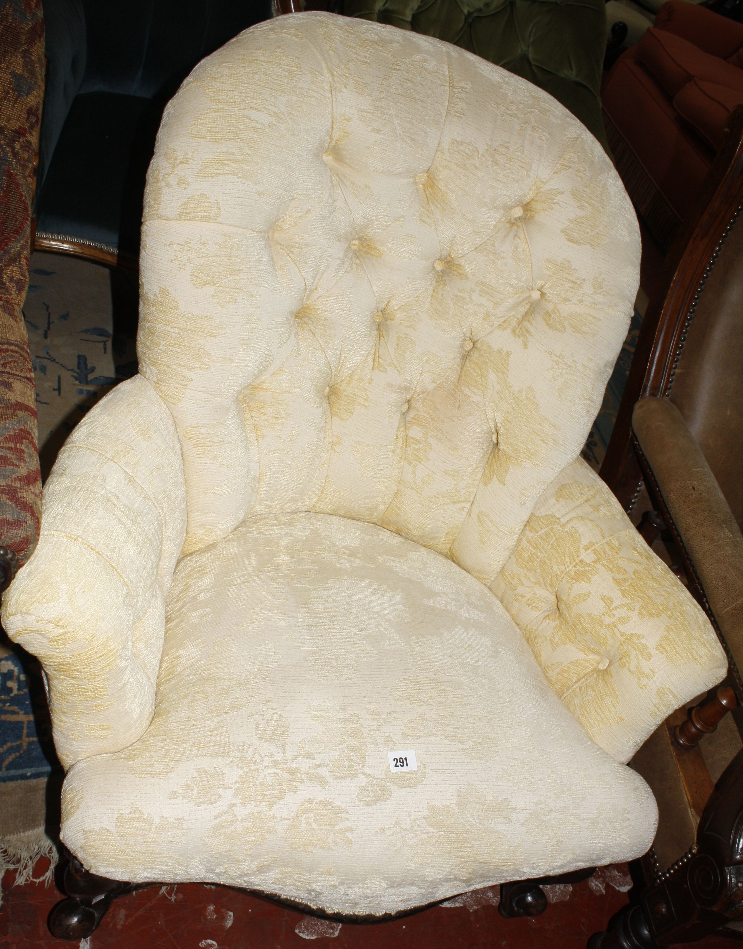 A Victorian upholstered button back armchair