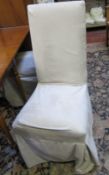 A set of six dining chairs with loose cream cushions