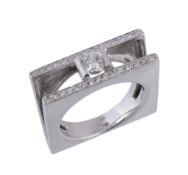 A diamond ring, the central brilliant cut diamond in a part collet setting between two rows of