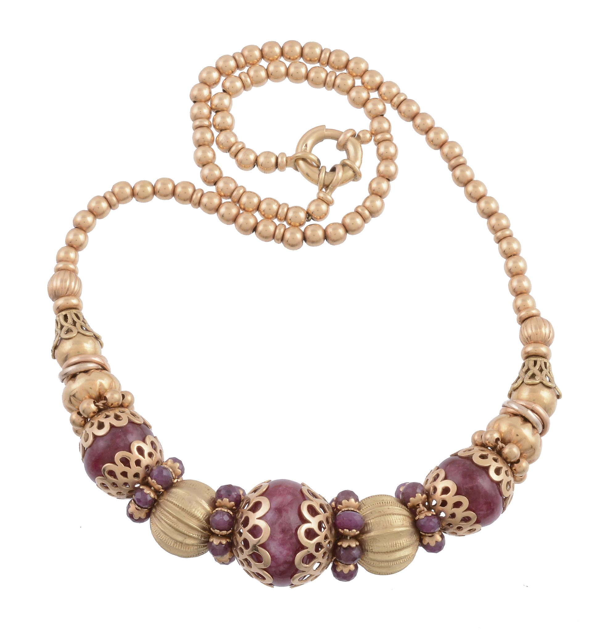 A ruby bead necklace, the central polished ruby bead in a pierced scallop setting between further