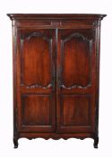 A Louis XV walnut armoire , circa 1750, the pair of arched and panelled...  A Louis XV walnut