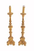 A pair of Italian carved and giltwood altar candlesticks, circa 1900  A pair of Italian carved and