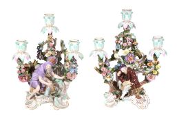Two similar Meissen figural three-branch flower-encrusted candelabra  Two similar Meissen figural