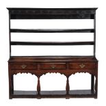 A George III oak dresser, the three open shelves with wrought iron cup hooks  A George III oak