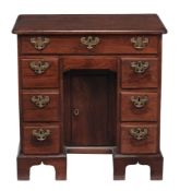 A George II red walnut kneehole desk, circa 1730  A George II  red walnut kneehole desk,   circa