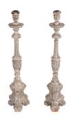 A pair of Spanish or Portuguese carved and silvered pine altar candlesticks  A pair of Spanish or