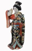 A Kutani Porcelain Figure of a Bijin, she stands elegantly posed wearing on...  A Kutani Porcelain