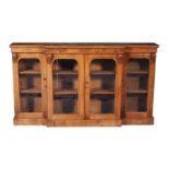 A Victorian walnut breakfront display cabinet, circa 1860, the top with plain frieze and acanthus