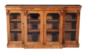 A Victorian walnut breakfront display cabinet, circa 1860, the top with plain frieze and acanthus
