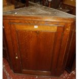 An 18th Century oak corner cupboard with panelled door enclosing shelves Best Bid