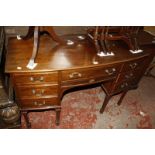 An Edwardian bow front dressing table fitted with seven drawers, on square tapered legs, 122cm