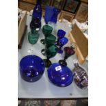 A collection of coloured glass to include blue glass wines, bowls green glass etc
