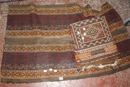 An Eastern rug and saddlebag