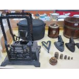 A quantity of black cast iron items to include a pot with cover, irons, an oak barrel and oak