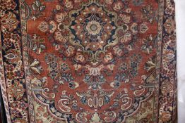 A Meshed rug, the red field with central foliate medallion and scattered with flowers within