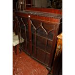 An early 20th century mahogany bow front display cabinet enclosed by a pair of tracery glazed doors,