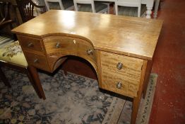 A mahogany dressing table in Regency style with central concave drawer flanked by drawers on