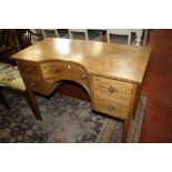 A mahogany dressing table in Regency style with central concave drawer flanked by drawers on