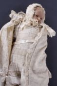 A 19th century baby doll. Wax head attached to a cloth body, blond human hair, stationary blue glass