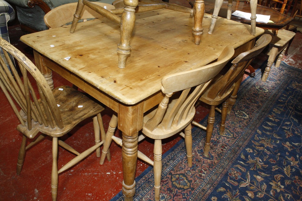 An old pine kitchen table, raised on turned supports.