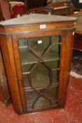 A mahogany corner cupboard with astragal glazed door enclosing painted shelves 86cm high, 55cm wide