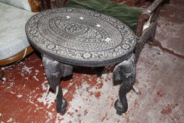 An Indian carved hardwood oval table on elephant head style legs 76cm