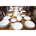 A part dinner service, white ground with stylised floral border