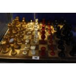 A bone and stained chess set, another wooden chess set and a chess board (each set missing two
