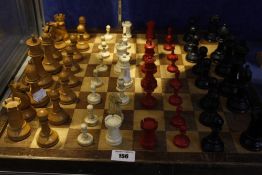 A bone and stained chess set, another wooden chess set and a chess board (each set missing two