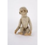 An early 20th Century plush monkey with animated head and wagging tail.
