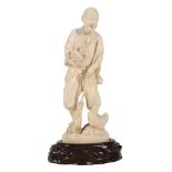 A Japanese Ivory Okimono of a Farmer, he stands holding a nest in one hand... A Japanese Ivory