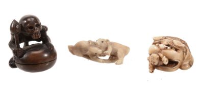 An Ivory Netsuke carved in the form of two boys scrambling out from under a... An Ivory Netsuke