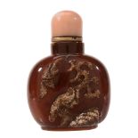 An Agate Snuff Bottle of a dark honey tone An Agate Snuff Bottle of a dark honey tone, carved in
