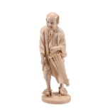 An Ivory Okimono of a Townsman, he protectively lifts the hem of his robe as... An Ivory Okimono