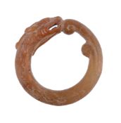 A Chinese Archaistic Jade Pendant, of annular form carved in the yellowish... A Chinese Archaistic