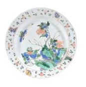 A Chinese Famille Verte dish, Kangxi, painted with a butterfly above peony... A Chinese Famille