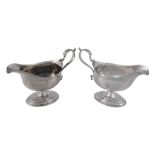 Two similar Georgian silver pedestal sauce boats,   one with overstruck mark by Peter and Ann