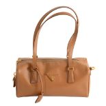 Prada, a tan textured leather barrel handbag,   with an applied Prada motif and optional padlock