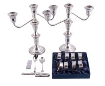 A pair of silver coloured three light candlesticks,   stamped Sterling, with bell shaped capitals,