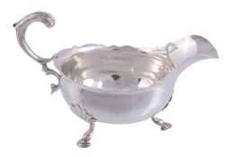 A George II silver shaped oval sauce boat by John Pollock,   London  1754, with a leaf capped