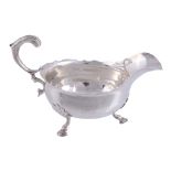 A George II silver shaped oval sauce boat by John Pollock,   London  1754, with a leaf capped